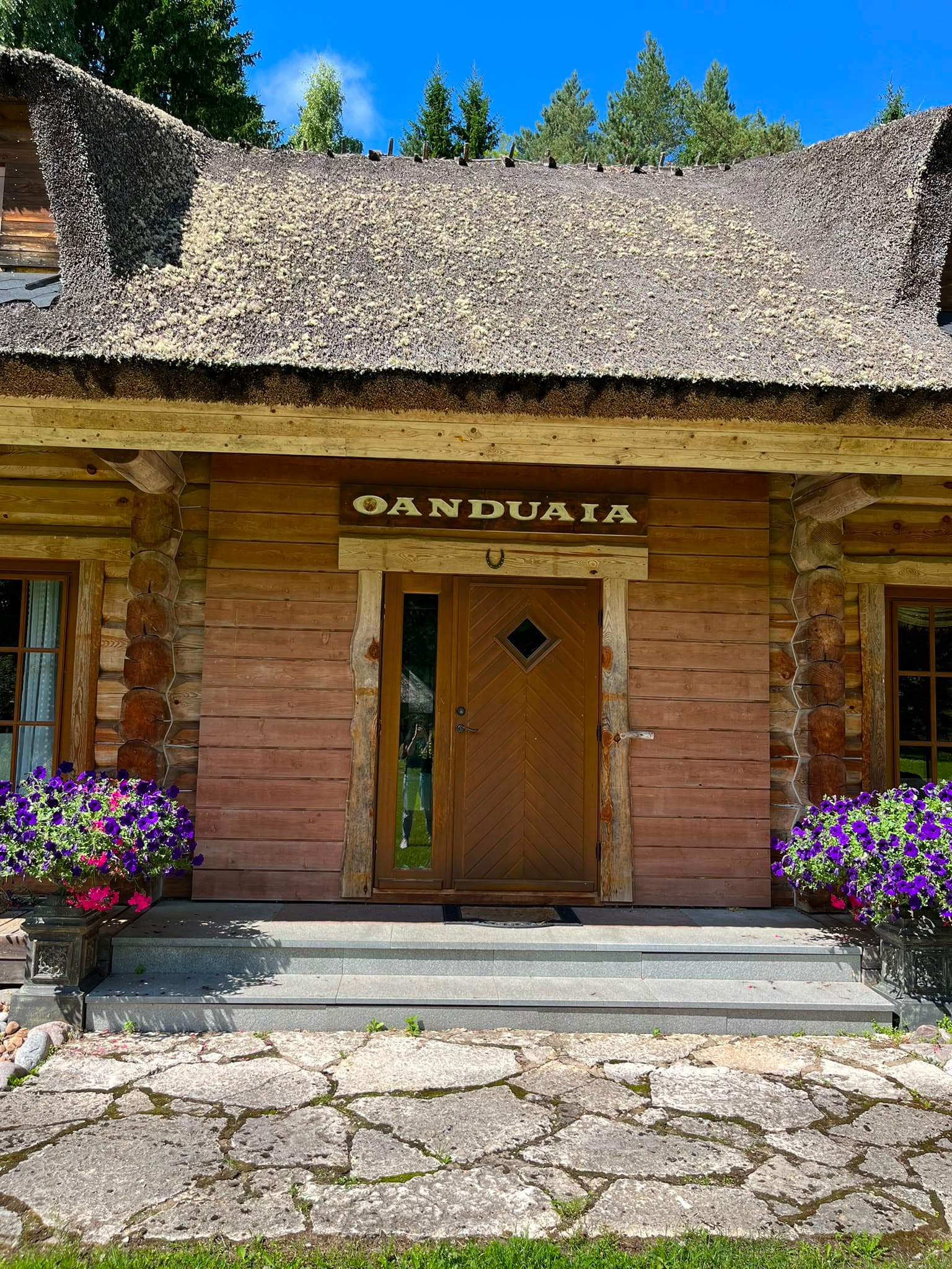 The main house with its thatched roof and log walls