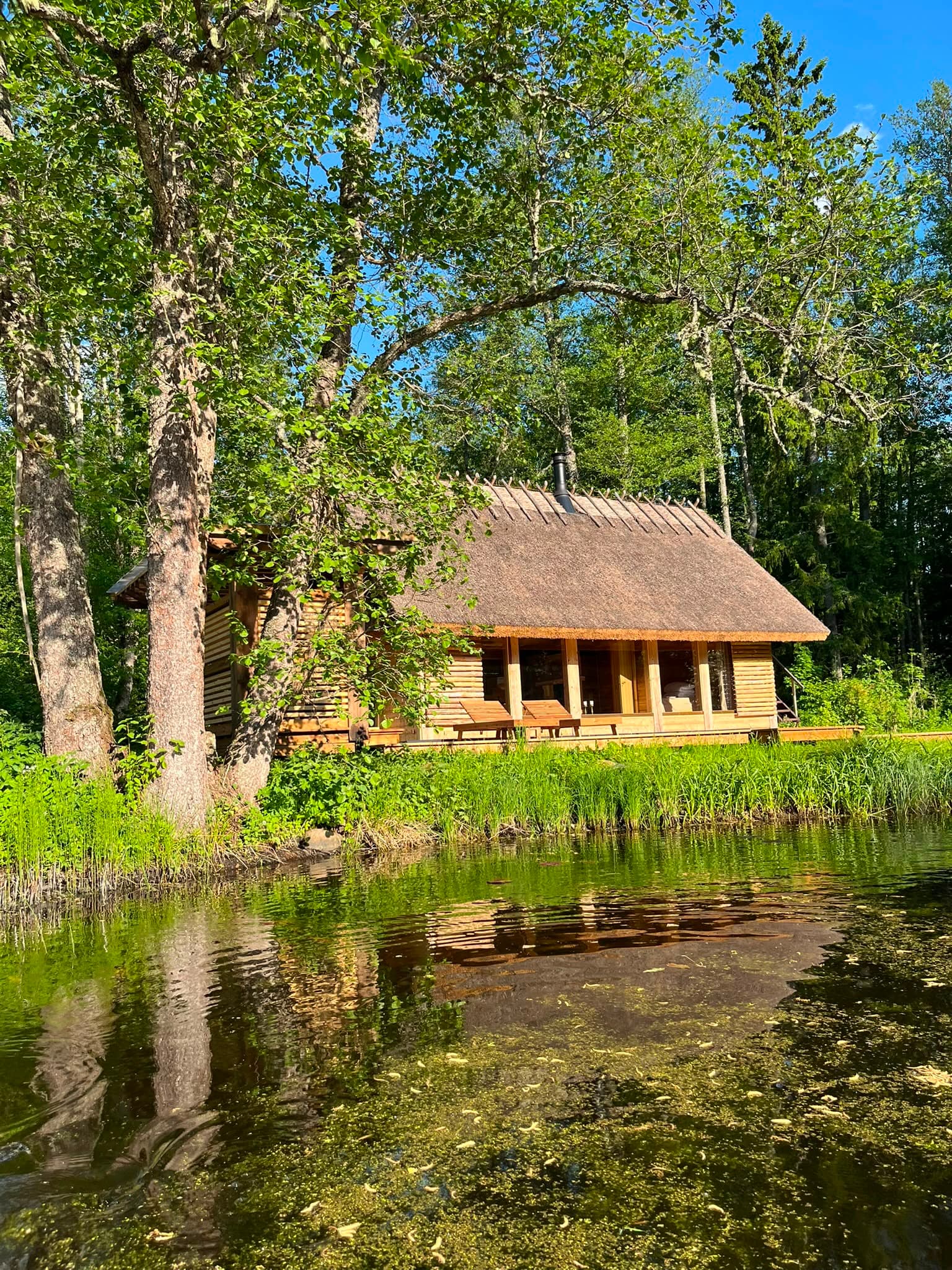 The Pond House across the water, house and forest mirrored in the pond
