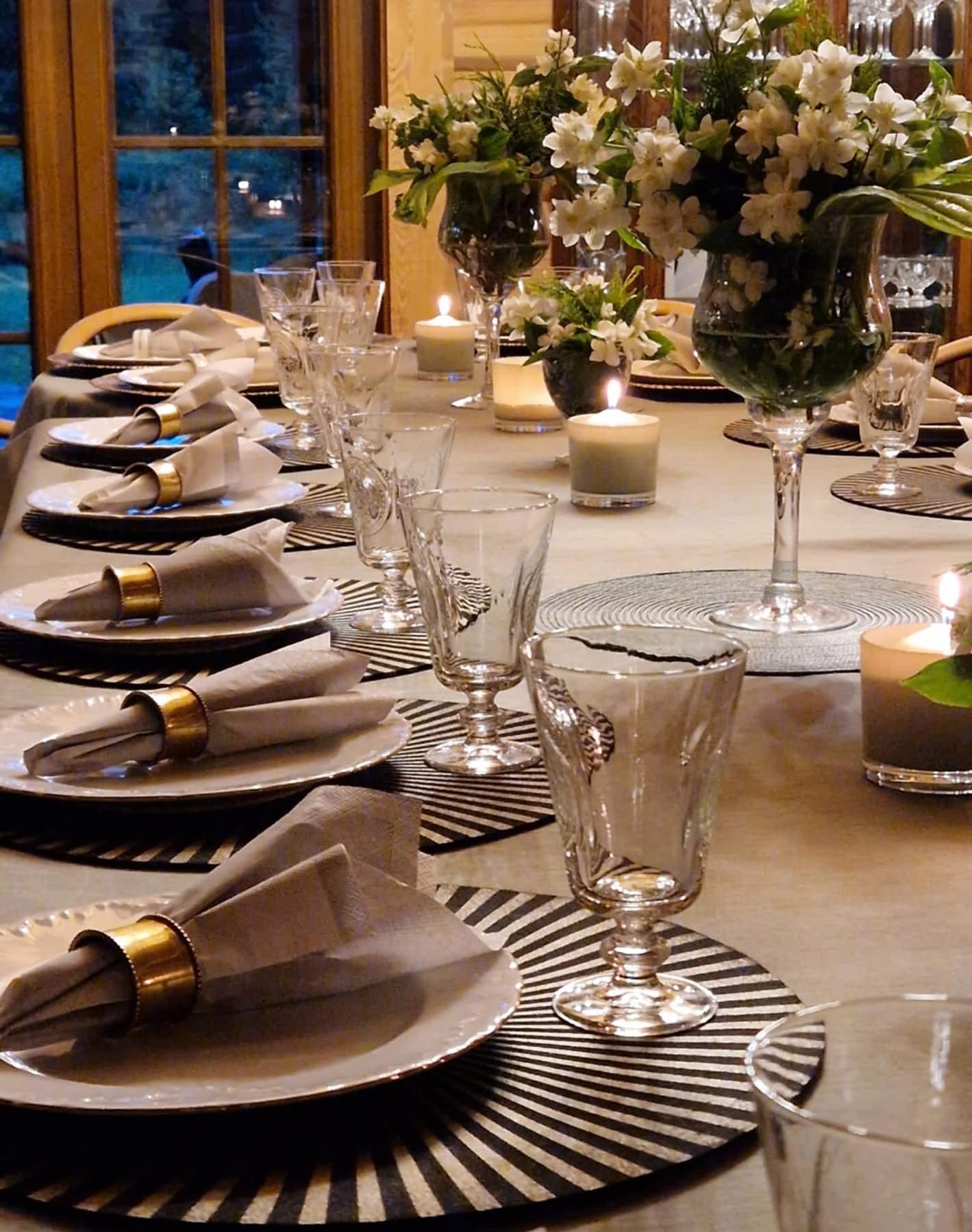 The long table by candlelight, with brass napkin rings and jars of jasmine