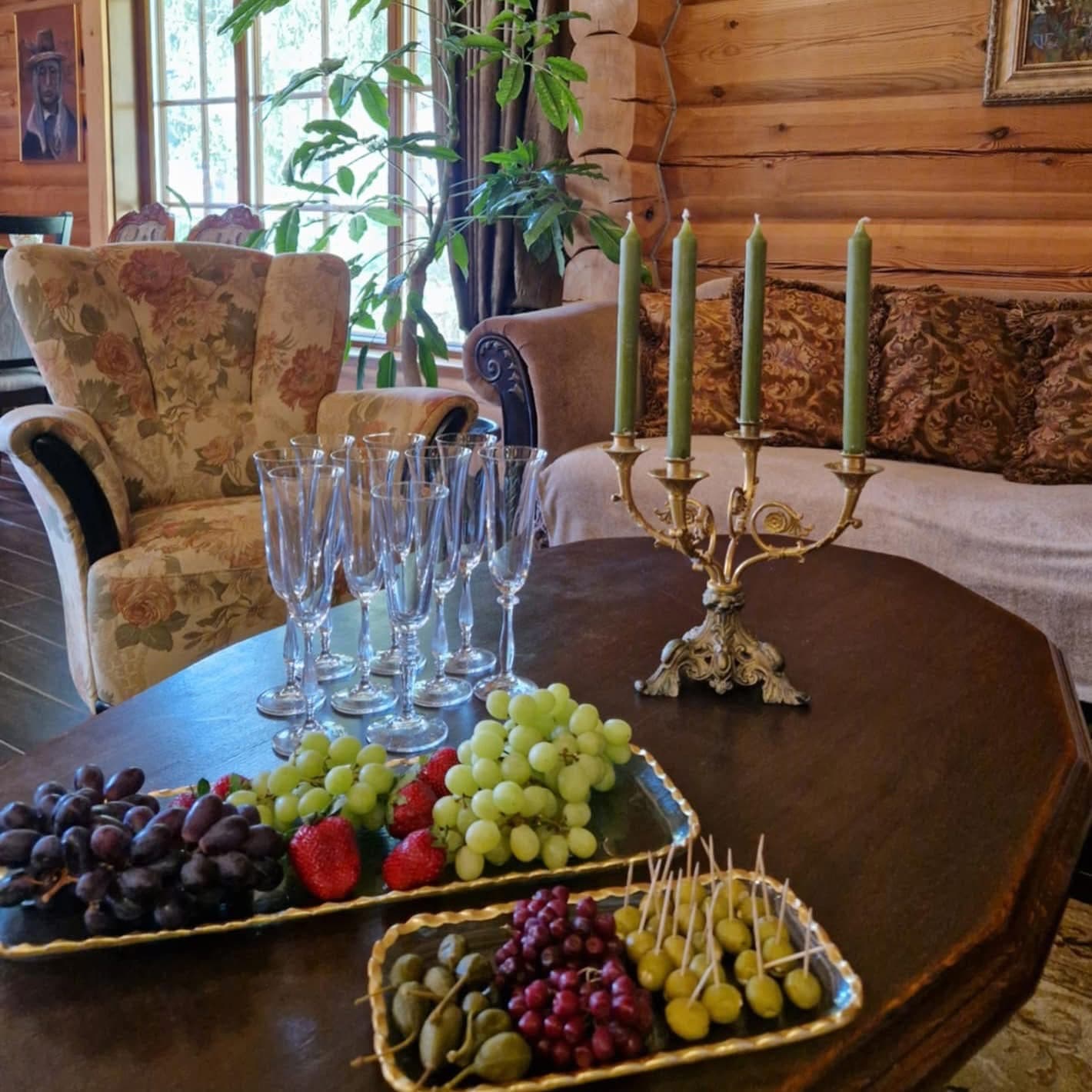 Grapes, strawberries and olives on trays, champagne flutes and a brass candelabra