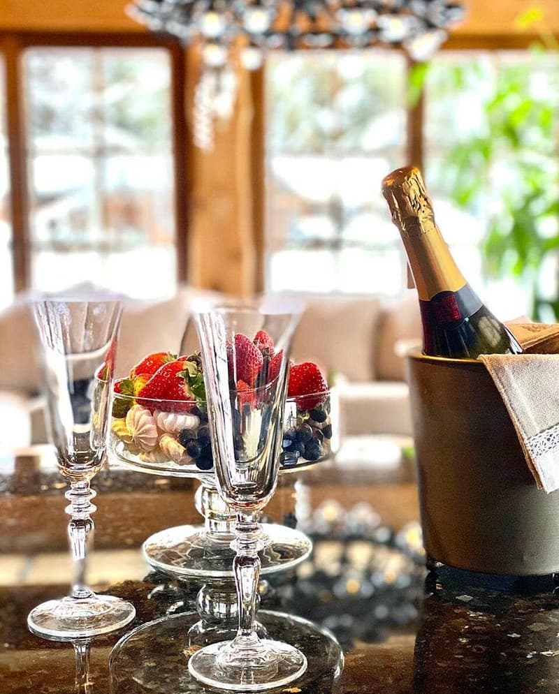 Sauna House — sparkling wine and berries beside crystal glasses on the granite table